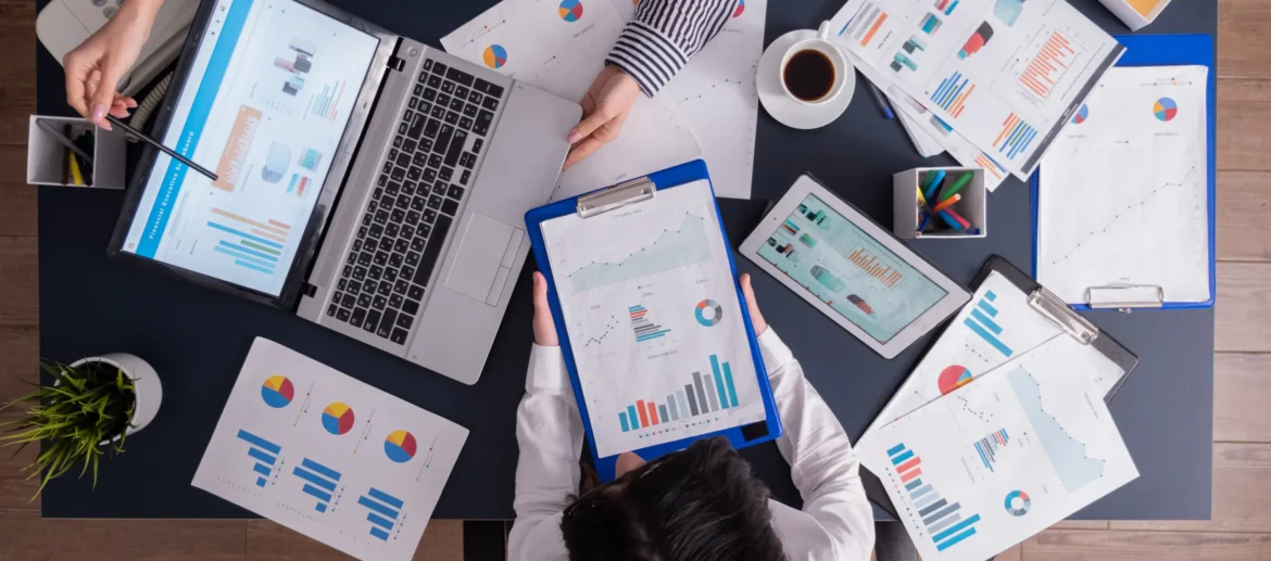 top-viewtop-view-manager-employee-doing-teamwork-business-office-looking-charts-laptop-display_11zon